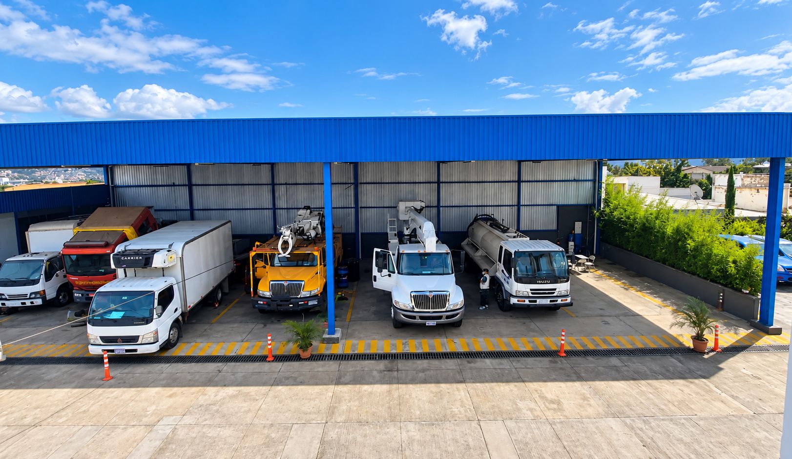 Camiones de carga, grúas canasta y cisterna bajo la nave de servicio de RECASA