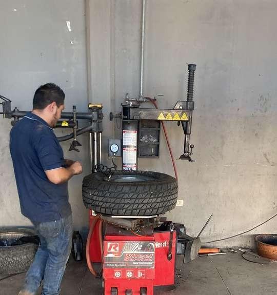 Técnico en la desmontadora de llantas
